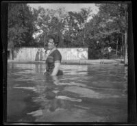 Emma Manker stands in an outdoor swimming pool known as Lewis Lake, Elliott vicinity, 1900