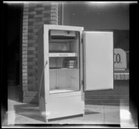 Woodlin electric refrigerator stands on a sidewalk with its door open, Los Angeles, 1948