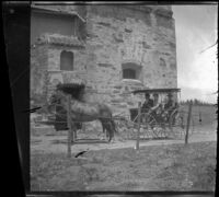 Visitors to San Gabriel Mission sit in their carriage parked in front of the mission, San Gabriel, about 1896