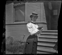 Minnie Kellum stands in front of the front porch steps of the Kellum residence, Los Angeles, about 1899