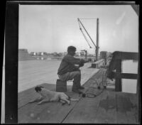 A fisherman mending his net on the wharf in San Pedro, Los Angeles, about 1898