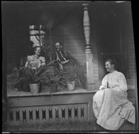 Edith Parsons and William Biddick sit in chairs on a porch while Fannie Mead Biddick sits on the steps, Burlington, 1900