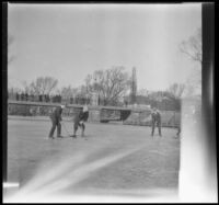 Men play ice hockey on a frozen pond in the Public Garden, Boston, 1914