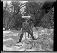 Mertie West helps H. H. West, Jr. balance a block of ice on his head, Redlands vicinity, about 1930