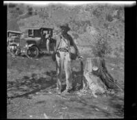 H. H. West holds fish and fishing gear, Mono County vicinity, 1929