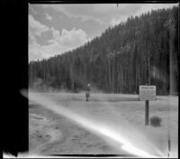 Mertie West stands at the edge of Emerald Pool, Yellowstone National Park, 1942