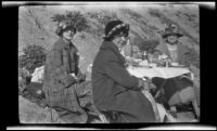 Edith Shaw, Mertie Whitaker and Josie Shaw dining at a table on the beach, Carpinteria vicinity, about 1924