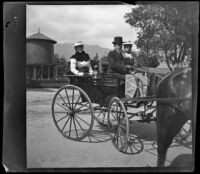 Louise Ambrose, H. H. West and Nella West sit in a carriage near the Lamanda Park water tank, Pasadena, 1899