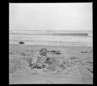 Frances West sits in a hole in the sand, Venice, about 1910