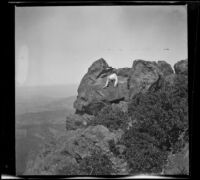 Nella West sitting on boulders at the summit of Mount Tamalpais, Marin County, about 1900