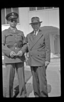 H. H. West, Jr. and H. H. West pose on the sidewalk in front of the West's residence, Los Angeles, 1944