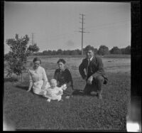 Gertrude Teel, Hattie Cline, John Teel and baby Ambrose Cline sit in a field at John Teel's ranch, Los Angeles, [about 1915]