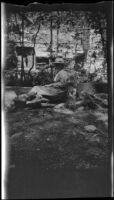 H. H. West, Jr. lounges near a neighboring dwelling, San Bernardino County, about 1924