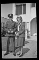 H. H. West, Jr. and Mertie West stand on the sidewalk in front of the West's residence, Los Angeles, 1944