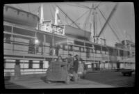 Tow cart driving along the wharf past a docked ship, Valdez, 1946