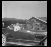 Mary West sits in H. H. West's Mitchell car, which is parked in front of their house, Los Anglees, about 1916