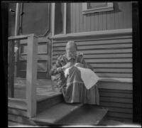 Wilhelmina West sews while sitting on the back porch of the West's house, Los Angeles, about 1899