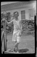 H. H. West Jr. leans on a wooden post in a backyard, Los Angeles, about