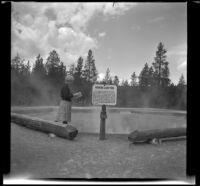 Mertie West looks at a guidebook while visiting Morning Glory Pool, Yellowstone National Park, 1942