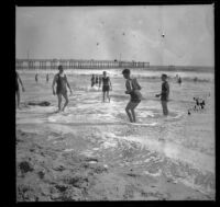 Men play in the surf with the pier in the background, Santa Monica, about 1895