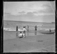 Beachgoers stand and sit in the surf at North Beach, Santa Monica, about 1895