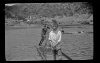 H. H. West, Jr. and Ambrose Cline stand on a raft in the lagoon, Topanga, about 1922