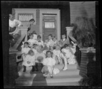 Group of children sits on the front steps of the West's house, Los Angeles, about 1907