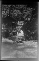 Glen Velzy sits in a chair and does some mending, San Gabriel Mountains, 1941