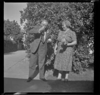 Evert West eats an orange while his wife, Myrtle, looks on, Santa Ana, 1941