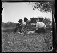 Charlie Rucher, Nella West and Louise Ambrose sit in the grass near Devils Gate, Pasadena, 1899