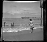 People on the beach with a pier in the background, Santa Monica, about 1895