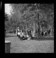 Mertie West stands behind a bench in Lincoln Park during the Iowa State Picnic, Los Angeles, 1948