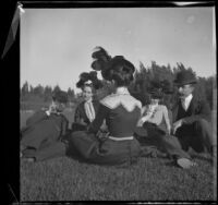 Ben Tyler, Lena Weideman, Mary Dixon, Daisy Connor, and Mr. Weideman sit on the grass in Lincoln (Eastlake) Park, Los Angeles, about 1900