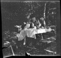 Mertie West, Agnes Whitaker and Forrest Whitaker dine at a picnic table at Soper's Ranch, Ojai vicinity, about 1927