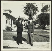 H. H. West and Gilbert Cecil West shake hands while standing on H. H. West's front walk [photo, recto], Los Angeles, 1941