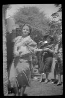 Woman stands by a tree at the Iowa Picnic in Lincoln Park, Los Angeles, 1939