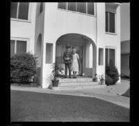 H. H. West, Jr. and Mertie West pose on the front porch of the West's new residence, Los Angeles, 1944