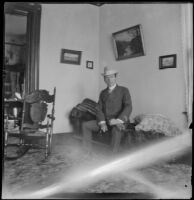 H. H. West sits on a sofa in the parlor of the West's house at 240 South Griffin Avenue, Los Angeles, 1899