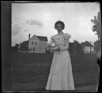 Ellen Lorene (Pinkie) Lemberger stands outside holding a plate, Ottumwa, 1900