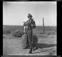 H. H. West, Jr. posing with a gun and a rabbit, Rosamond vicinity, about 1930