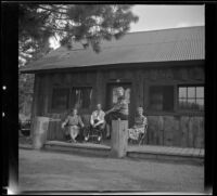 Maud West, Wayne West, Agnes Whitaker and Mertie West sit outside their cabin at Knight's Camp, Big Bear Lake, 1944