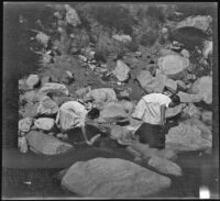 Elizabeth West and Frances West scramble across rocks, Sunland-Tujunga vicinity, 1912