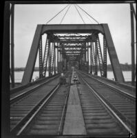 H. H. West and his cousin, Fred Lemberger, sit on a trestle locomotive bridge over the Mississippi River, Burlington, 1900