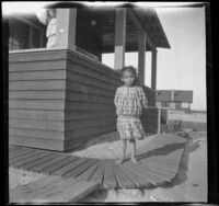 Elizabeth West stands by the West's beach cottage, while Wilhelmina West stands on the porch, Venice, about 1909