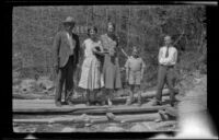 Wilson West, Mertie West, Eleanor West, Richard West and H. H. West, Jr. posing atop wood planks, Redlands vicinity, 1932