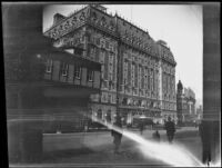 Men walk on the sidewalk across the street from the Hotel Astor, New York, 1914