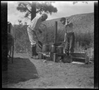 H. H. West and H. H. West Jr. at a camping stove, Inyo County vicinity, about 1930