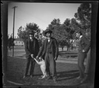 Guy West and Frank Lemberger play with the neighbor's dog while Arleigh Lemberger stands by them, Los Angeles, 1900