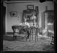 George M. West sits at the table in the library of the West's house at 240 South Griffin Avenue, Los Angeles, 1897