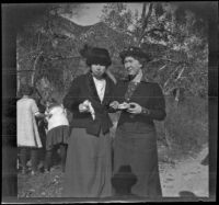 Mrs. H. H. West (Mary A.) and Bessie McGee Velzy pose for a photograph while they eat, Sunland-Tujunga vicinity, 1912